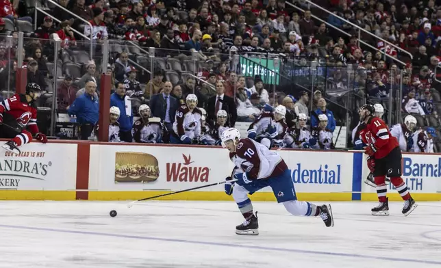 Colorado Avalanche defenseman Sam Malinski (70) chases the puck during the second period of an NHL hockey game against the New Jersey Devils, Sunday, Dec. 8, 2024, in Newark, N.J. (AP Photo/Stefan Jeremiah)