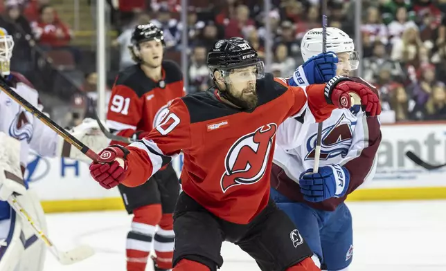 New Jersey Devils left wing Tomas Tatar (90) is pushed by Colorado Avalanche defenseman Cale Makar, right, during the second period of an NHL hockey game, Sunday, Dec. 8, 2024, in Newark, N.J. (AP Photo/Stefan Jeremiah)
