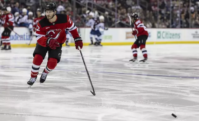 New Jersey Devils defenseman Brett Pesce chases after the puck during the first period of an NHL hockey game against the Colorado Avalanche, Sunday, Dec. 8, 2024, in Newark, N.J. (AP Photo/Stefan Jeremiah)