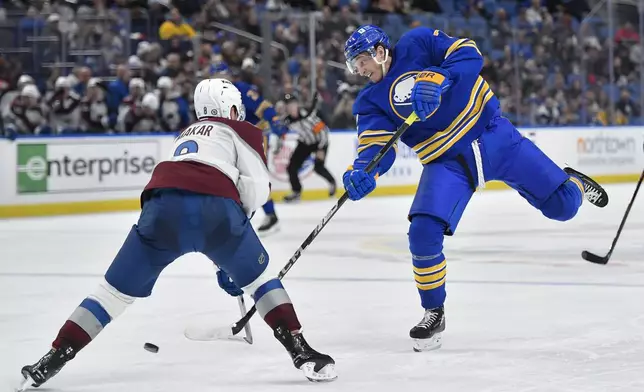 Buffalo Sabres center Tage Thompson, right, shoots while defended by Colorado Avalanche defenseman Cale Makar during the second period of an NHL hockey game in Buffalo, N.Y., Tuesday, Dec. 3, 2024. (AP Photo/Adrian Kraus)