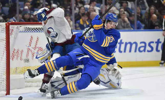 Buffalo Sabres defenseman Owen Power, right, collides with Colorado Avalanche right wing Logan O'Connor during the first period of an NHL hockey game in Buffalo, N.Y., Tuesday, Dec. 3, 2024. (AP Photo/Adrian Kraus)