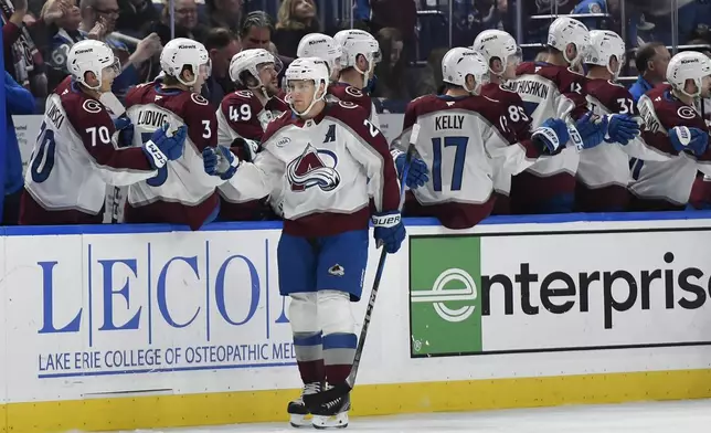 Colorado Avalanche center Nathan MacKinnon (29) celebrates with teammates after scoring during the second period of an NHL hockey game against the Buffalo Sabres in Buffalo, N.Y., Tuesday, Dec. 3, 2024. (AP Photo/Adrian Kraus)