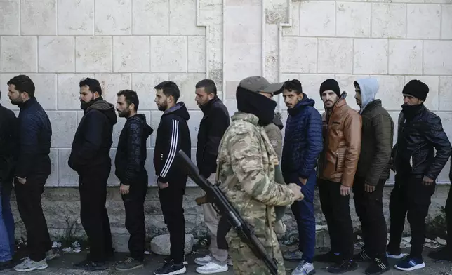 FILE - Members from Bashar Assad's Syrian army period line up to register with Syrian rebels as part of a "identification and reconciliation process" at a army compound in Latakia, Syria, Tuesday, Dec. 17, 2024. (AP Photo/Leo Correa, File)