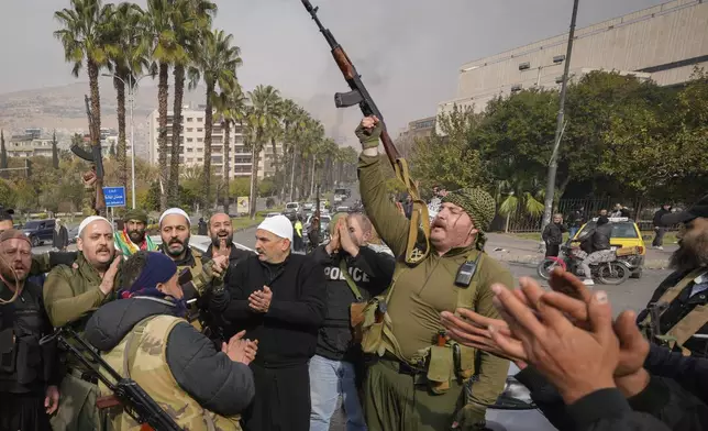 FILE - Opposition fighters celebrate the takeover of the city by the insurgents in Damascus, Syria, Sunday, Dec. 8, 2024. (AP Photo/Hussein Malla, File)