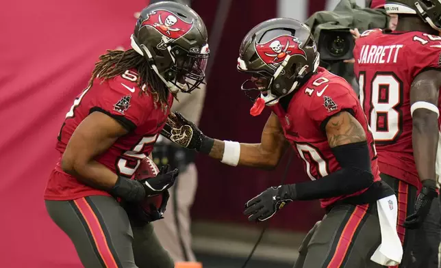 Tampa Bay Buccaneers linebacker J.J. Russell celebrates after scoring on a blocked punt with wide receiver Trey Palmer during the second half of an NFL football game against the Carolina Panthers Sunday, Dec. 29, 2024, in Tampa, Fla. (AP Photo/Chris O'Meara)