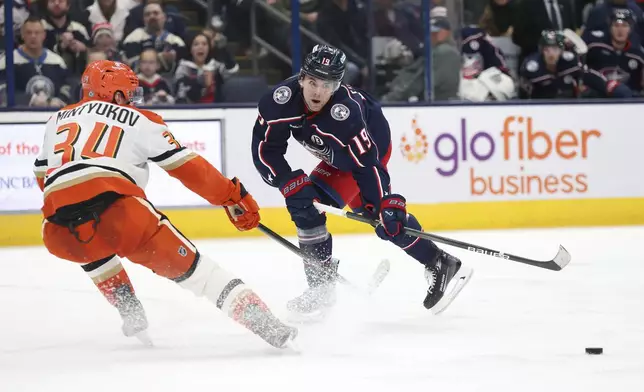 Columbus Blue Jackets center Adam Fantilli (19) shoots the puck as Anaheim Ducks defenseman Pavel Mintyukov (34) defends during the second period of an NHL hockey game Saturday, Dec. 14, 2024, in Columbus, Ohio. (AP Photo/Joe Maiorana)