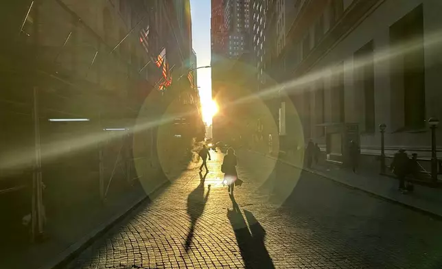 People walk on Wall Street in New York's Financial District on Wednesday, Dec. 18, 2024. (AP Photo/Peter Morgan, File)