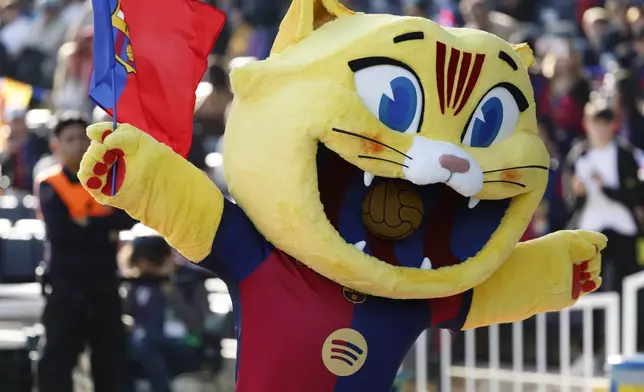 Barcelona's mascot Cat waves a flag prior to a Spanish La Liga soccer match against Las Palmas at the Lluis Companys Olympic Stadium in Barcelona, Spain, Saturday Nov. 30, 2024. (AP Photo/Joan Monfort)