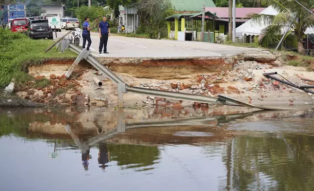 Men survey the damage caused by a flood in Tumpat, on the outskirts of Kota Bahru in Kelantan state on the east coast of Malaysia, Tuesday, Dec. 3, 2024. (AP Photo/Vincent Thian)