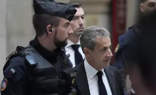 FILE - Former French President Nicolas Sarkozy arrives at the courtroom for his appeal trial of trying to bribe a magistrate in exchange for information about a legal case in which he was implicated Monday, Dec. 5, 2022 in Paris. (AP Photo/Francois Mori, File)