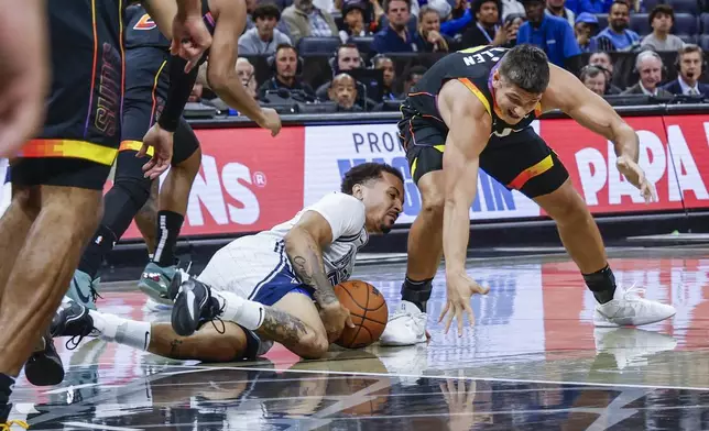 Orlando Magic guard Cole Anthony, left, grabs the ball on the floor against Phoenix Suns guard Grayson Allen, right, during the first half of an NBA basketball game, Sunday, Dec. 8, 2024, in Orlando, Fla. (AP Photo/Kevin Kolczynski)