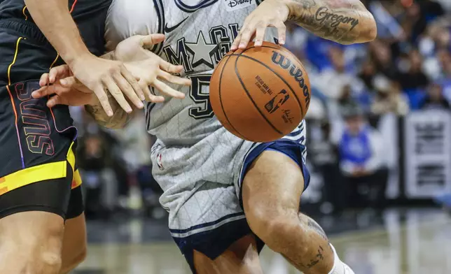 Orlando Magic guard Cole Anthony, right, is fouled by Phoenix Suns guard Grayson Allen, left, during the first half of an NBA basketball game, Sunday, Dec. 8, 2024, in Orlando, Fla. (AP Photo/Kevin Kolczynski)