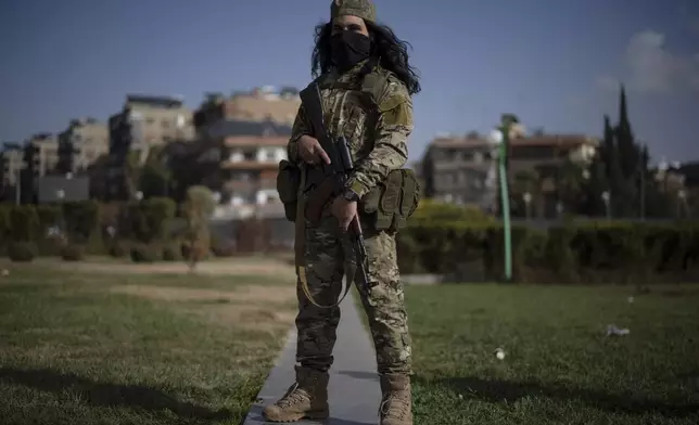 A member of the new armed forces, former rebel who took part in the overthrow of Bashar Assad's government and now serves in the new Syrian government, poses for a picture as he stands at a square before a military parade in Damascus, Syria, Friday, Dec. 27, 2024. (AP Photo/Leo Correa)