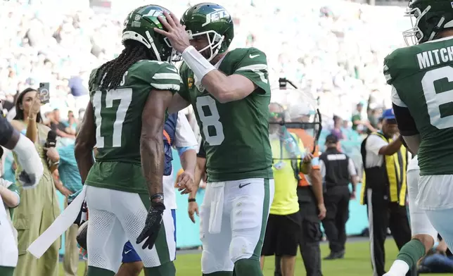 New York Jets quarterback Aaron Rodgers (8) and New York Jets wide receiver Davante Adams (17) celebrate a touchdown during the second half of an NFL football game against the Miami Dolphins, Sunday, Dec. 8, 2024, in Miami Gardens, Fla. (AP Photo/Lynne Sladky)