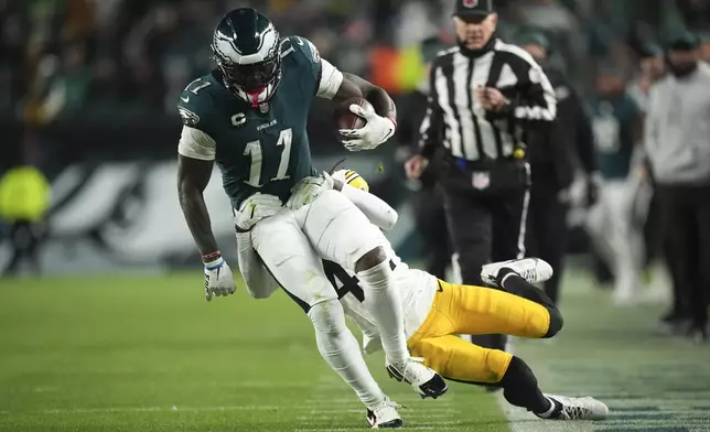 Philadelphia Eagles wide receiver A.J. Brown (11) runs with the ball as Pittsburgh Steelers cornerback James Pierre (42) tries to stop him during the second half of an NFL football game Sunday, Dec. 15, 2024, in Philadelphia. (AP Photo/Matt Slocum)