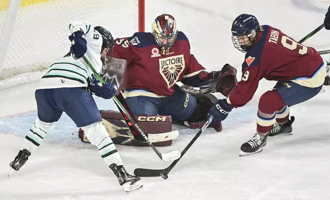 Montreal Victoire's Kati Tabin (9) defends Boston Fleet's Hannah Bilka (19) as she moves in on Victoire goaltender Ann-Renee Desbiens during second period PWHL hockey action in Laval, Que., Monday, Dec. 30, 2024. (Graham Hughes/The Canadian Press via AP)