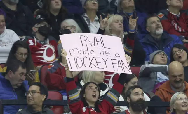 A fan holds a sign during second-period PWHL hockey game action between the Ottawa Charge and the Montreal Victoire in Ottawa, Ontario, Friday, Dec. 6, 2024. (Patrick Doyle/The Canadian Press via AP)