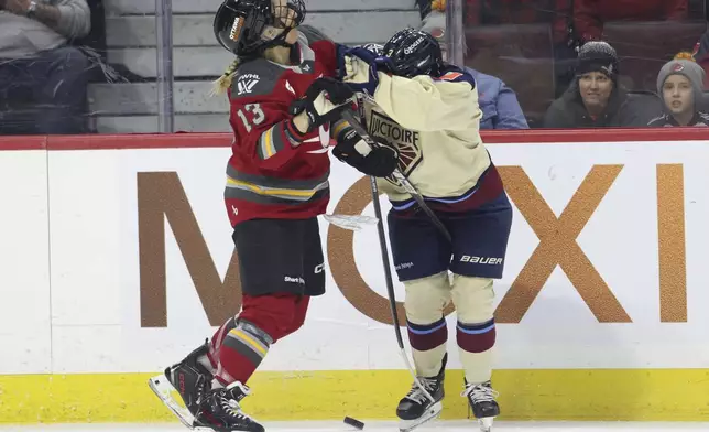 Ottawa Charge's Tereza Vanisova (13) and Montreal Victoire's Cayla Barnes (3) struggle for the puck during the first period of a PWHL hockey game in Ottawa, Ontario on Friday, Dec. 6, 2024. (Patrick Doyle/The Canadian Press via AP)