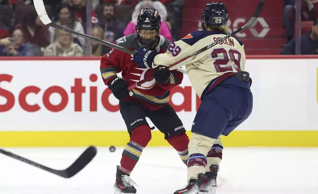 Ottawa Charge's Aneta Tejralova, left, and Montreal Victoire's Marie-Philip Poulin (29) struggle for the puck during first-period PWHL hockey game action in Ottawa, Ontario, Friday, Dec. 6, 2024. (Patrick Doyle/The Canadian Press via AP)