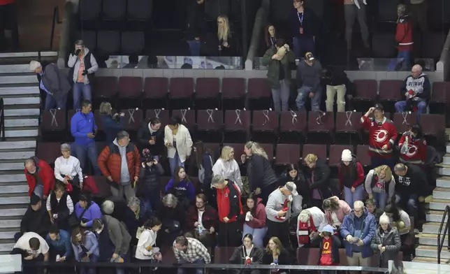 Fourteen seats with ribbons are left empty before PWHL hockey game action in honor of the victims of the Montreal Polytechnique massacre committed 35 years ago, in Ottawa, Ontario, Friday, Dec. 6, 2024. (Patrick Doyle/The Canadian Press via AP)