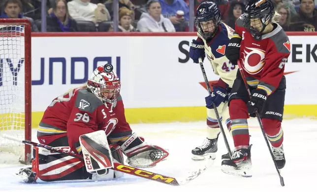 Ottawa Charge goaltender Emerance Maschmeyer (38) makes a save as Charge's Aneta Tejralova (2) and Montreal Victoire's Kristin O'Neill (43) look on during third-period PWHL hockey game action in Ottawa, Ontario, Friday, Dec. 6, 2024. (Patrick Doyle/The Canadian Press via AP)