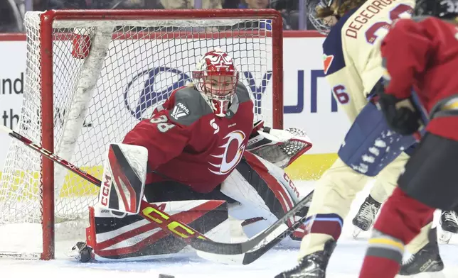 Ottawa Charge goaltender Emerance Maschmeyer (38) watches the puck as Montreal Victoire's Clair Degeorge (26) tries to score during third-period PWHL hockey game action in Ottawa, Ontario, Friday, Dec. 6, 2024. (Patrick Doyle/The Canadian Press via AP)