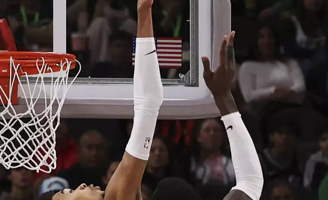 San Antonio Spurs center Victor Wembanyama, left, blocks a shot against Portland Trail Blazers center Deandre Ayton, right, during the first half of an NBA basketball game in San Antonio, Saturday, Dec. 21, 2024. (AP Photo/Kin Man Hui)