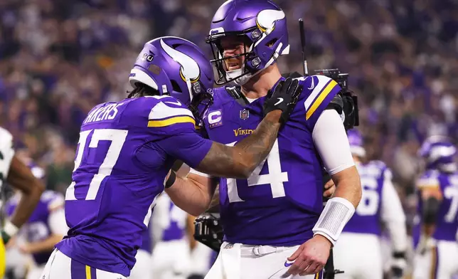 Minnesota Vikings' Sam Darnold congratulates Cam Akers on a touchdown catch during the second half of an NFL football game against the Green Bay Packers Sunday, Dec. 29, 2024, in Minneapolis. (AP Photo/Bruce Kluckhohn)