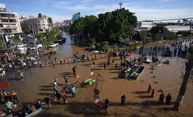 Volunteers gather in order to help residents evacuate from an area flooded in Porto Alegre, Brazil, May 7, 2024. (AP Photo/Andre Penner)