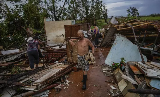 People recover belongings from their house, which was destroyed by Hurricane Rafael, in Alquizar, Cuba, Nov. 7, 2024. (AP Photo/Ramon Espinosa)