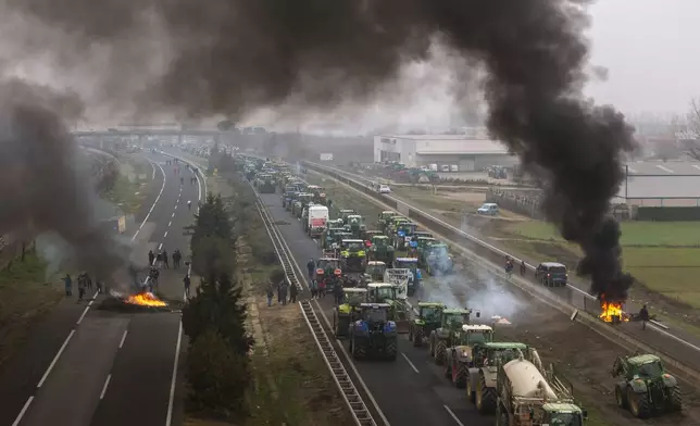 Farmers make barricades after blocking a highway during a protest near Mollerussa, Spain, Feb. 6, 2024. (AP Photo/Emilio Morenatti)