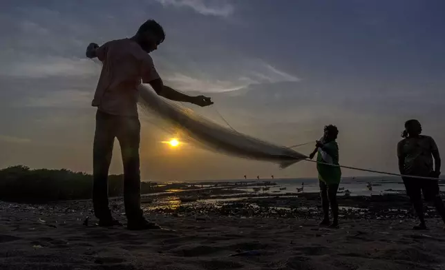 Fishermen fold a net near the shores of the Arabian Sea in Mumbai, India, Feb. 14, 2024. (AP Photo/Rafiq Maqbool)