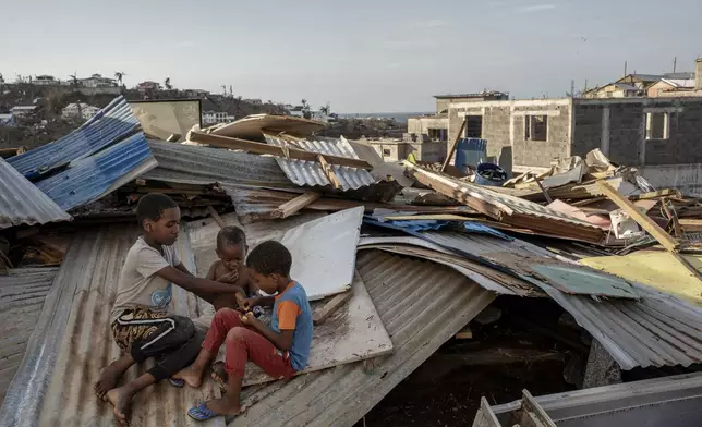 Children play in Majicavo Koropa, Mayotte, Friday, Dec. 20, 2024. (AP Photo/Adrienne Surprenant)