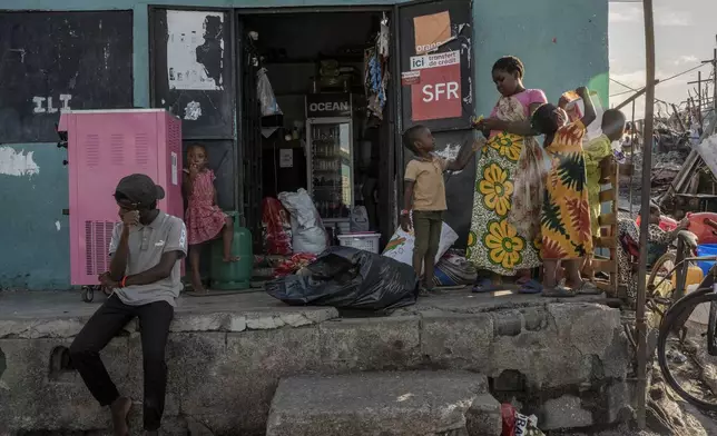 Children play in a small shop in Majicavo Koropa, Mayotte, Friday, Dec. 20, 2024. (AP Photo/Adrienne Surprenant)