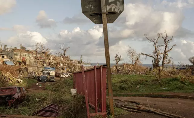 Containers, cars and debris litter the area near Longoni port, Mayotte, Friday, Dec. 20, 2024. (AP Photo/Adrienne Surprenant)