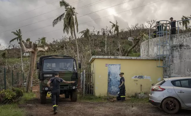 French civil security officers reach the water station in Mirereni, Mayotte, Friday, Dec. 20, 2024. (AP Photo/Adrienne Surprenant)