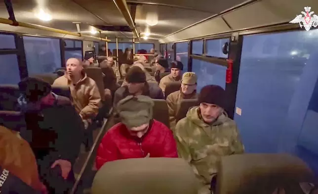 In this photo taken from video released by the Russian Defense Ministry Press Service on Monday, Dec. 30, 2024, a group of Russian soldiers sit in a bus after being released in a prisoners swap between Russia and Ukraine, at an unspecified location in Belarus. (Russian Defense Ministry Press Service via AP)