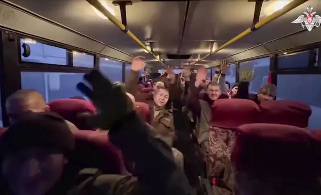 In this photo taken from video released by the Russian Defense Ministry Press Service on Monday, Dec. 30, 2024, a group of Russian soldiers sit in a bus after being released in a prisoners swap between Russia and Ukraine, at an unspecified location in Belarus. (Russian Defense Ministry Press Service via AP)