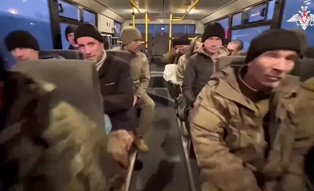 In this photo taken from video released by the Russian Defense Ministry Press Service on Monday, Dec. 30, 2024, a group of Russian soldiers sit in a bus after being released in a prisoners swap between Russia and Ukraine, at an unspecified location in Belarus. (Russian Defense Ministry Press Service via AP)