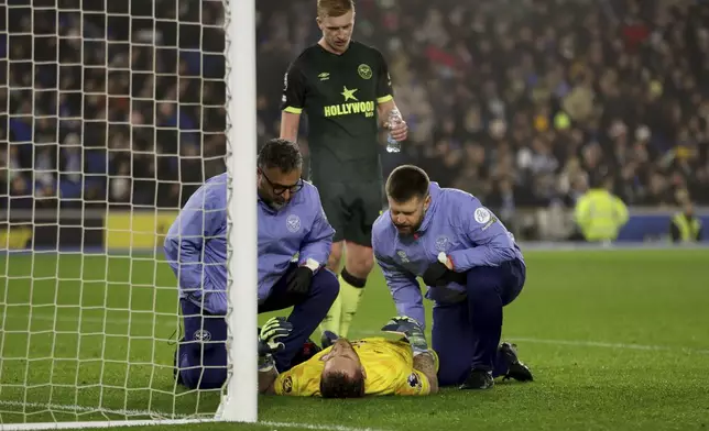 Brentford's goalkeeper Mark Flekken receives treatment for an injury during the English Premier League soccer match between Brighton &amp; Hove Albion and CF Brentford in Brighton and Hove, England, Friday, Dec 27, 2024. (Steven Paston/PA via AP)