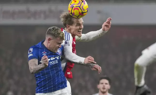 Arsenal's Martin Odegaard wins a header against Ipswich Town's Sammie Szmodics during the English Premier League soccer match between Arsenal and Ipswich at the Emirates Stadium in London, Friday, Dec. 27, 2024. (AP Photo/Kin Cheung)