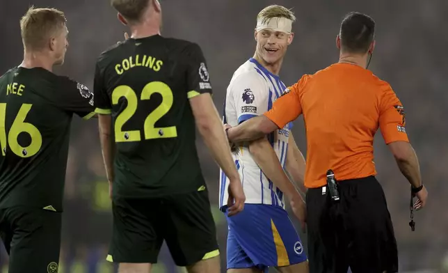 Brighton and Hove Albion's Jan Paul van Hecke, second right, is lead away by the referee Andrew Madley, right, following a clash with the oppositions players during the English Premier League soccer match between Brighton &amp; Hove Albion and CF Brentford in Brighton and Hove, England, Friday, Dec 27, 2024. (Steven Paston/PA via AP)