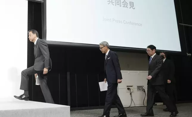 Nissan Chief Executive Makoto Uchida, left, and Honda Chief Executive Toshihiro Mibe, center, and Takao Kato CEO of Mitsubishi Motors, right, arrive to attend a joint news conference Monday, Dec. 23, 2024, in Tokyo, Japan. (AP Photo/Eugene Hoshiko)