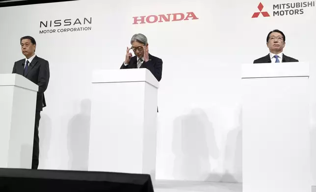 Nissan Chief Executive Makoto Uchida, left, and Honda Chief Executive Toshihiro Mibe, center, and Takao Kato CEO of Mitsubishi Motors, right, attend a joint news conference Monday, Dec. 23, 2024, in Tokyo, Japan. (AP Photo/Eugene Hoshiko)