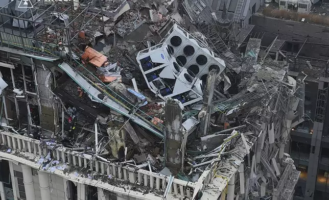 In this photo provided by the Ukrainian Emergency Service, firefighters work on the site of a damaged building after a Russian missile attack in Kyiv, Ukraine, Friday, Dec. 20, 2024. (Ukrainian Emergency Service via AP)