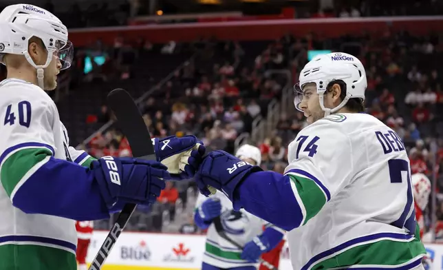 Vancouver Canucks left wing Jake DeBrusk (74) celebrates after his goal against the Detroit Red Wings with center Elias Pettersson (40) during the second period of an NHL hockey game Sunday, Dec. 1, 2024, in Detroit. (AP Photo/Duane Burleson)