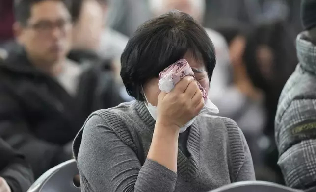 A relative of a passenger of a plane which burst into flames reacts at a temporary shelter at Muan International Airport in Muan, South Korea, Monday, Dec. 30, 2024. (AP Photo/Ahn Young-joon)