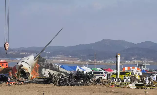 Rescue team members work at the site of a plane fire at Muan International Airport in Muan, South Korea, Monday, Dec. 30, 2024. (AP Photo/Ahn Young-joon)