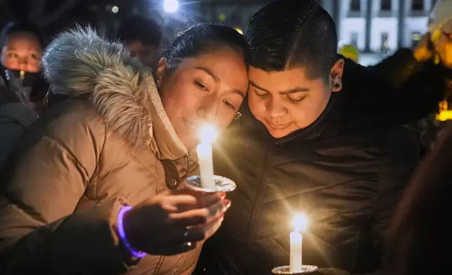 Supporters hold candles during a candlelight vigil Tuesday, Dec. 17, 2024, outside the Wisconsin Capitol in Madison, Wis., following a shooting at the Abundant Life Christian School on Monday, Dec. 16. (AP Photo/Morry Gash)