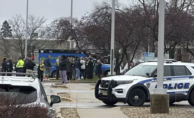 Emergency vehicles are parked outside of the SSM Health clinic where parents are being reunified with children after a shooting at the Abundant Life Christian School in Madison, Wis., Monday, Dec. 16, 2024. (AP Photo/Scott Bauer)